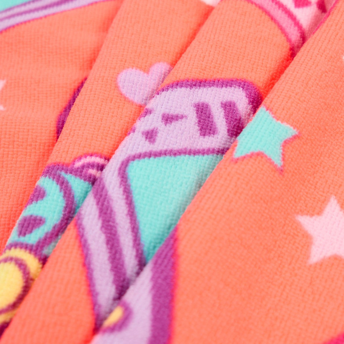 Detailed close-up of coral gamer microfibre towel fabric and print, children’s lightweight beach towel