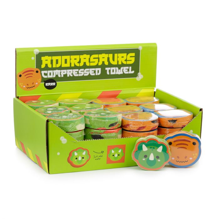Dinosaur compressed travel towels displayed in retail sales box with assorted dinosaur designs