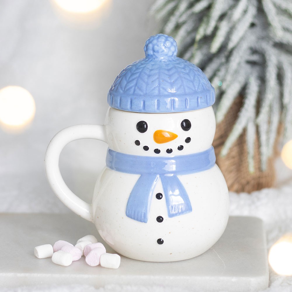 blue christmas snowman lidded mug displayed in a cosy home setting