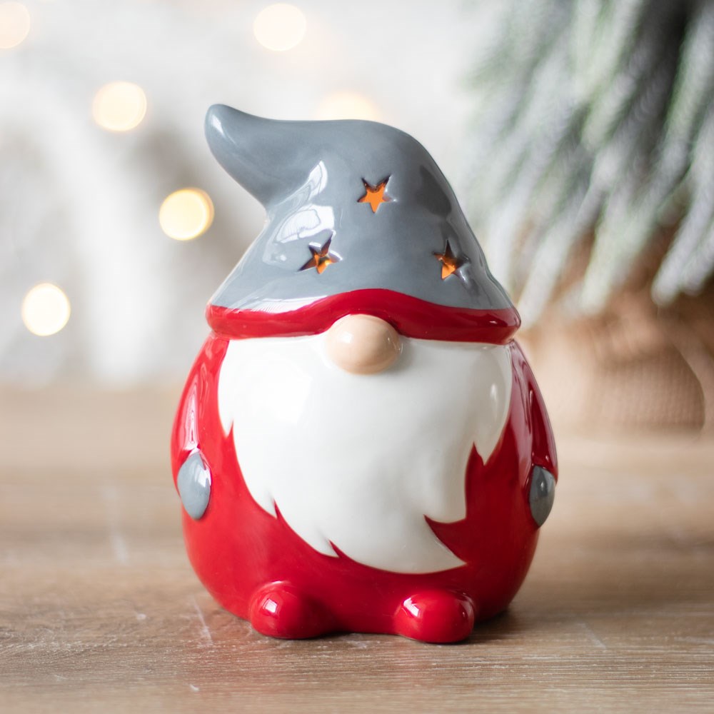red and grey christmas gonk tealight holder glowing through its starry hat in a home setting