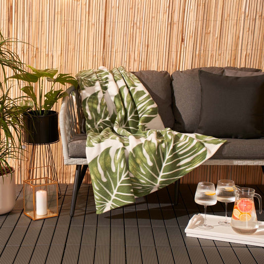 tropical leaf print fleece throw with green and nature-inspired design draped over furniture