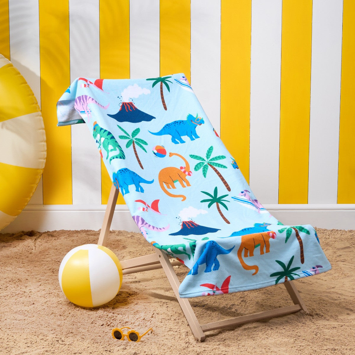 Children’s dinosaur microfibre beach towel with colourful dinosaurs on deckchair, kids quick-dry towel