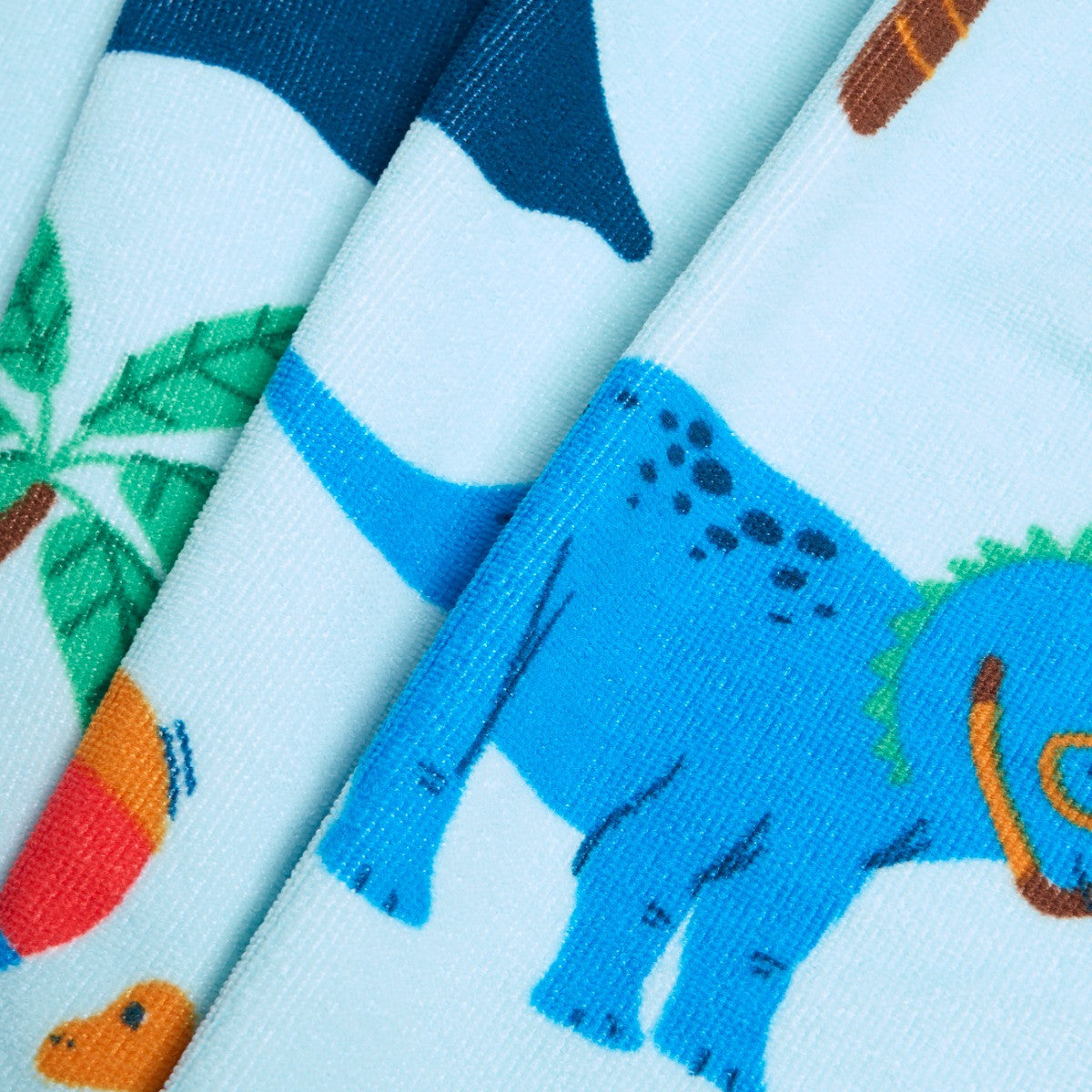 Close-up of dinosaur design on children’s microfibre beach towel, fun kids summer towel