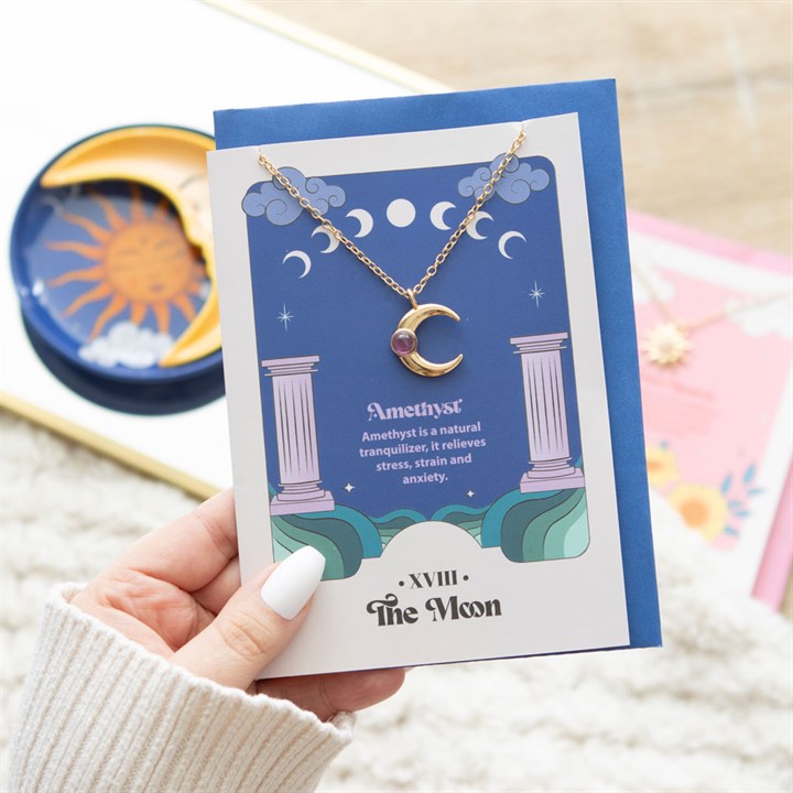 moon and amethyst crystal necklace styled in home setting with celestial tarot theme