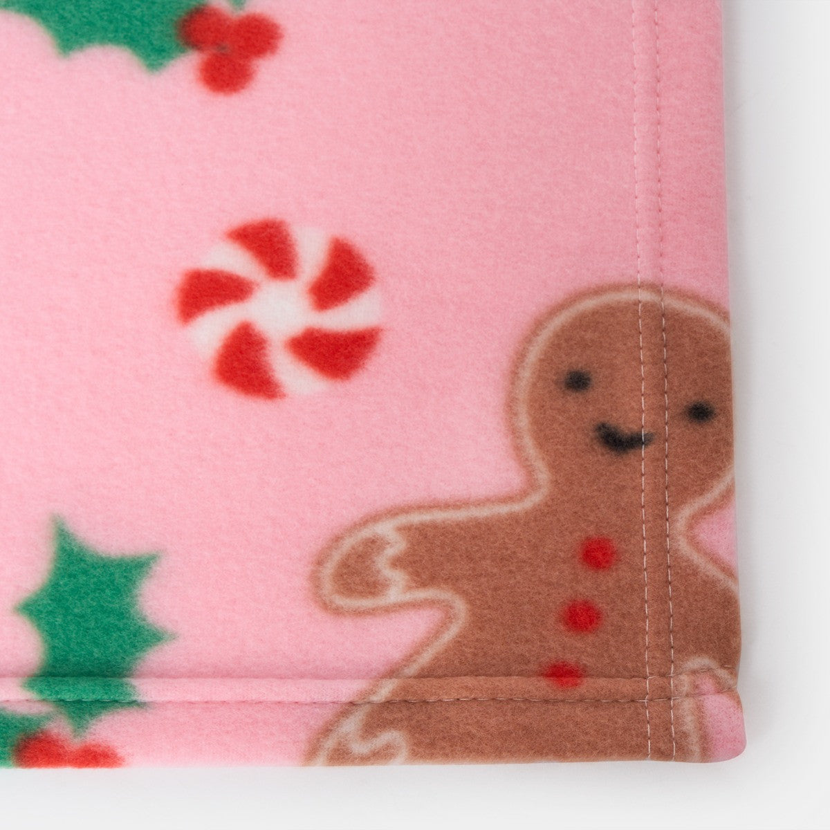 close-up of pink gingerbread fleece throw, highlighting soft texture and Christmas design details