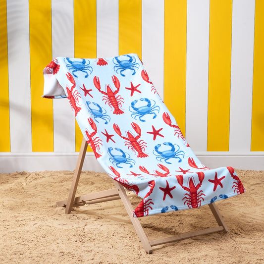 Lobster print beach towel draped over deckchair with blue coastal design