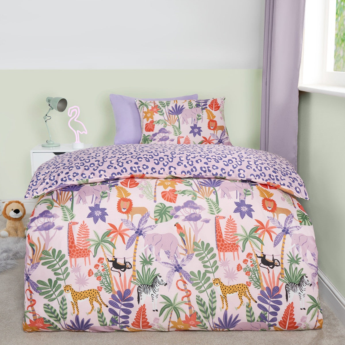 Safari print reversible double duvet cover set on bed with lions, giraffes and zebras on lilac background