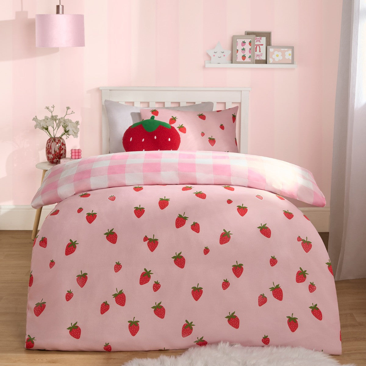 Children’s strawberry gingham reversible single duvet cover set on bed