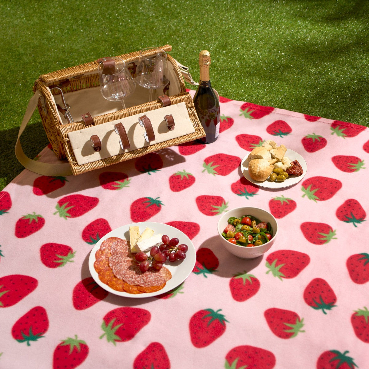 strawberry fleece throw styled in outdoor picnic setting as decorative and cosy blanket