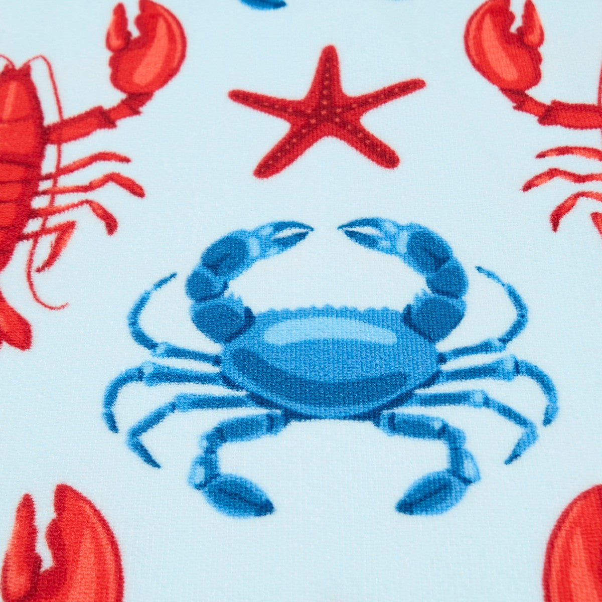 Close-up of lobster design on blue microfibre beach towel fabric