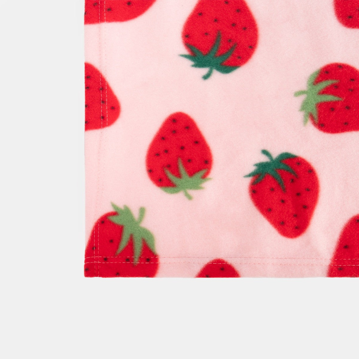 close up view of strawberry fleece throw fabric showing detailed strawberry pattern texture