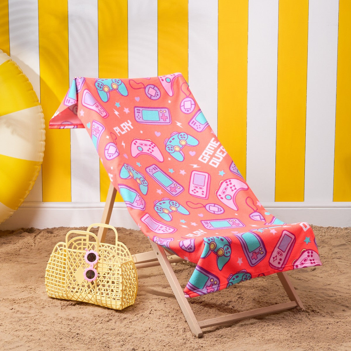 Children’s console gamer microfibre beach towel in coral displayed on a deckchair, gaming themed kids towel