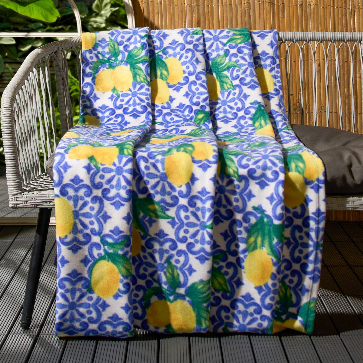 lemon print fleece throw draped over garden bench for outdoor relaxation