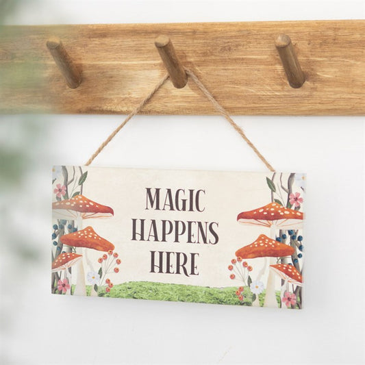 magic happens here mushroom hanging wooden sign styled in cosy home setting