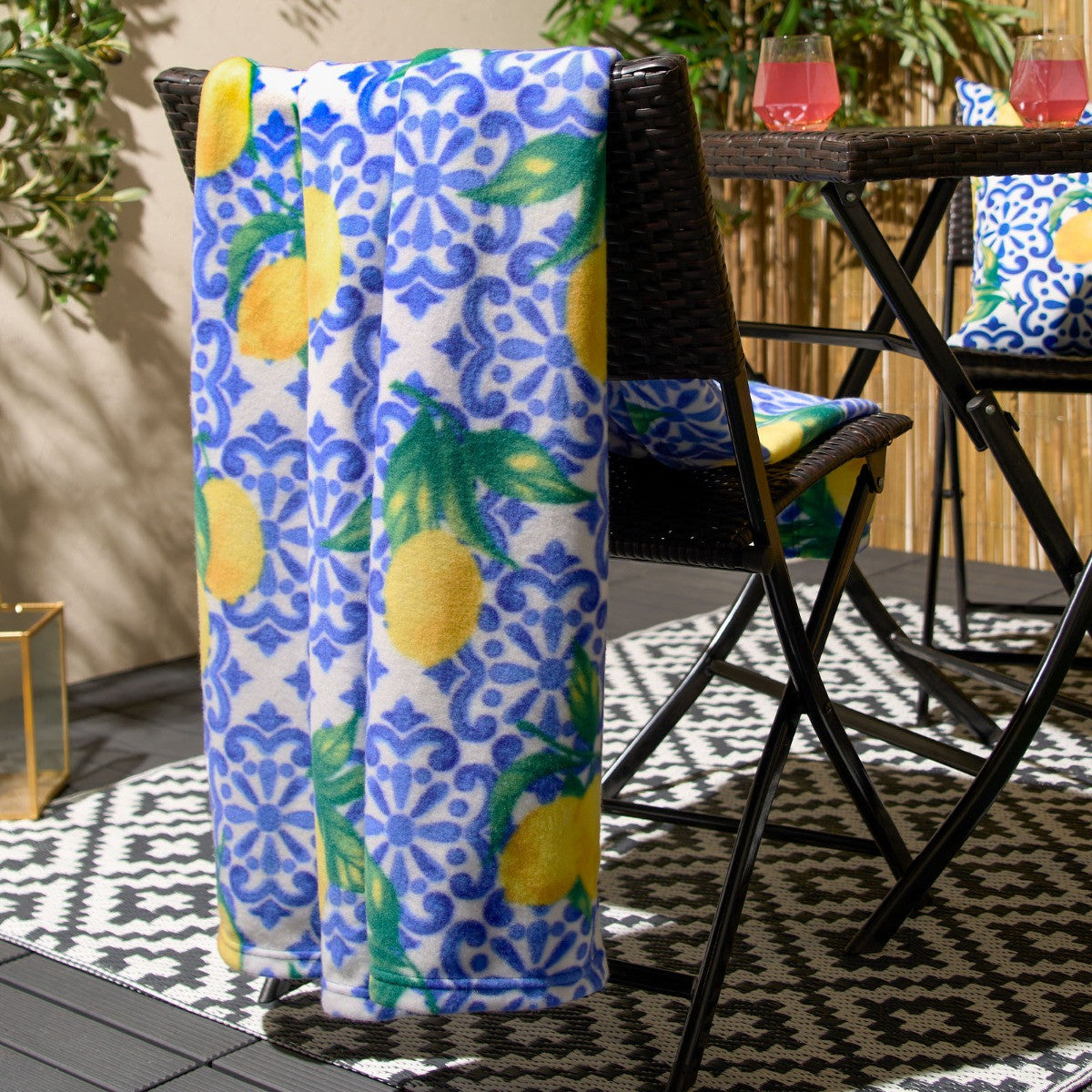 patterned fleece blanket styled over garden chair in outdoor setting