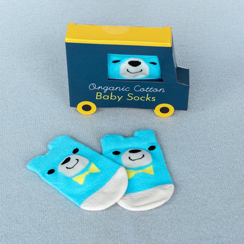 A pair of blue baby socks with a bear design, displayed next to a packaging box with a bear illustration.