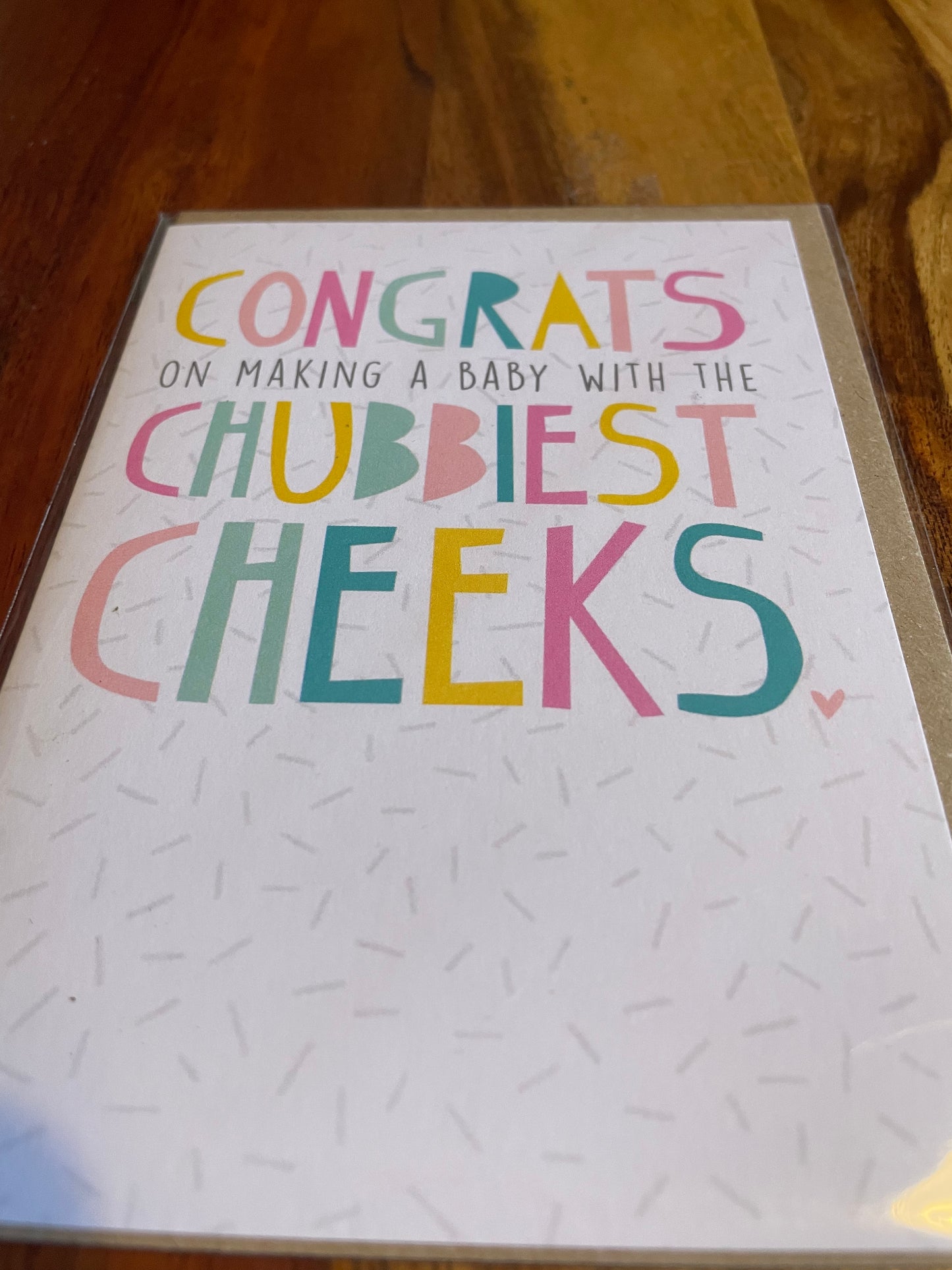 new baby greeting card with chubbiest cheeks text on white textured background