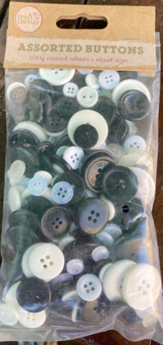 assorted black, white, and cream buttons in various sizes and styles, neatly arranged for crafting use